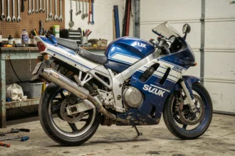 Moto Suzuki GSXR 1100 de 1992 vue de trois quarts avant dans un garage privé, avec carénages d'origine bleu et blanc légèrement patinés, idéale pour un contrôle avant achat